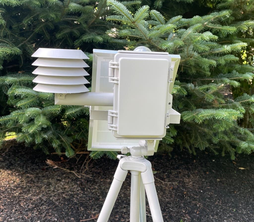 Station 001 enclosure, radiation shield, and solar panel on a field tripod